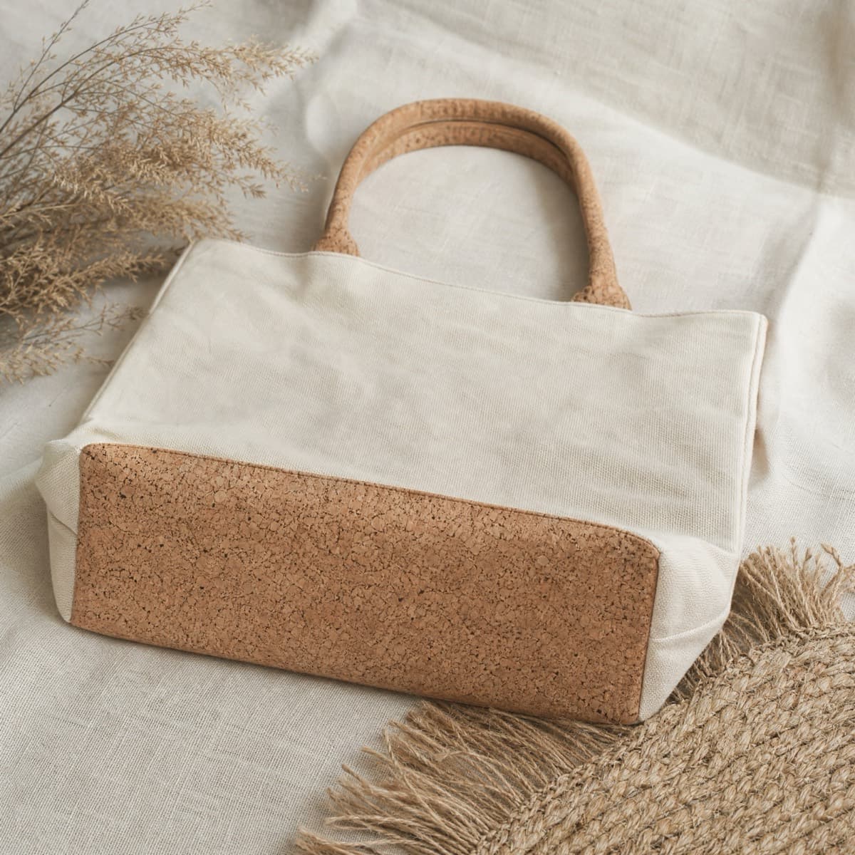 A canvas tote with a cork base panel and cork handles